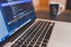 view of laptop from side with HTML code visible on screen
