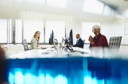 Two women and a man are working on their desk