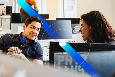 man and woman talking behind computer screen