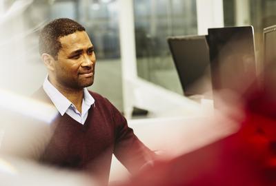 Man in an office looking at computer screen.