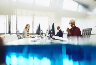 Two women and a man are working on their desk