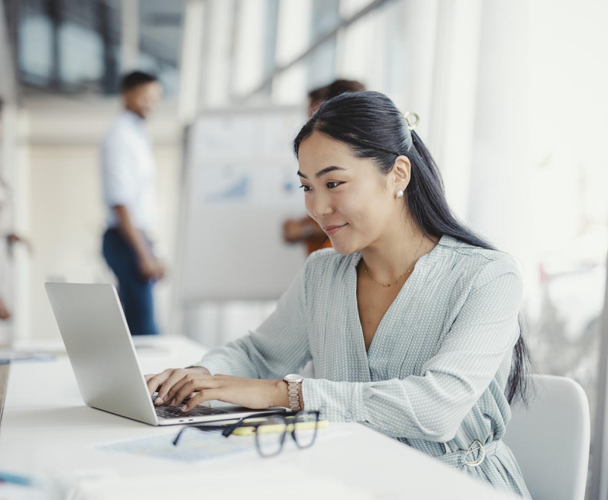 Photo of a woman working on her laptop in an office.