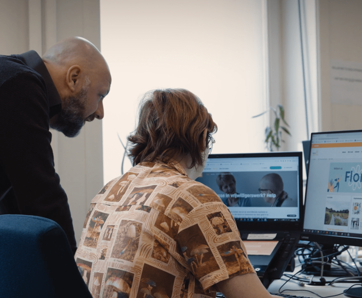 2 people looking at the Kom op tegen Kanker website.